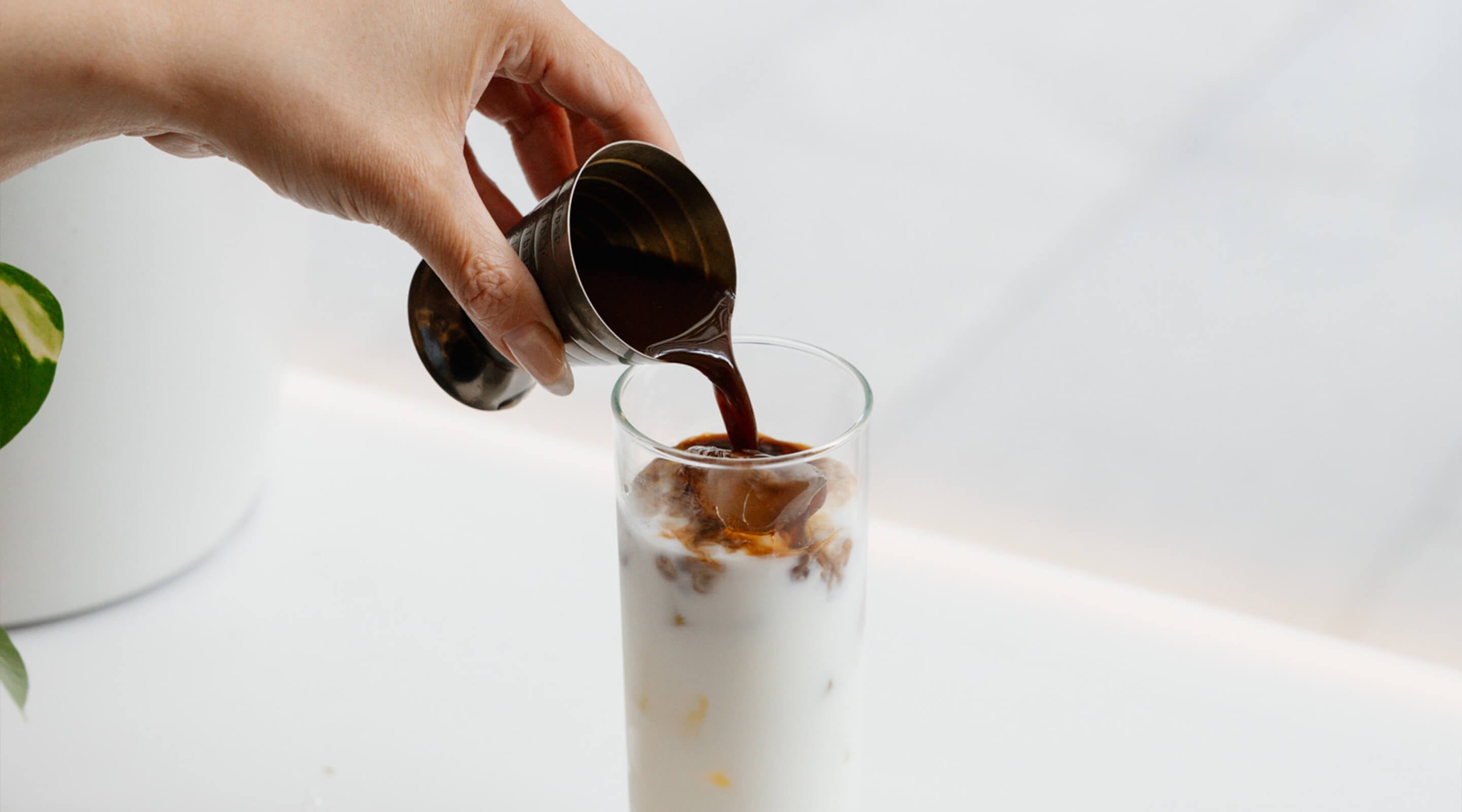Shot of Cold Brew Coffee poured into milk and ice