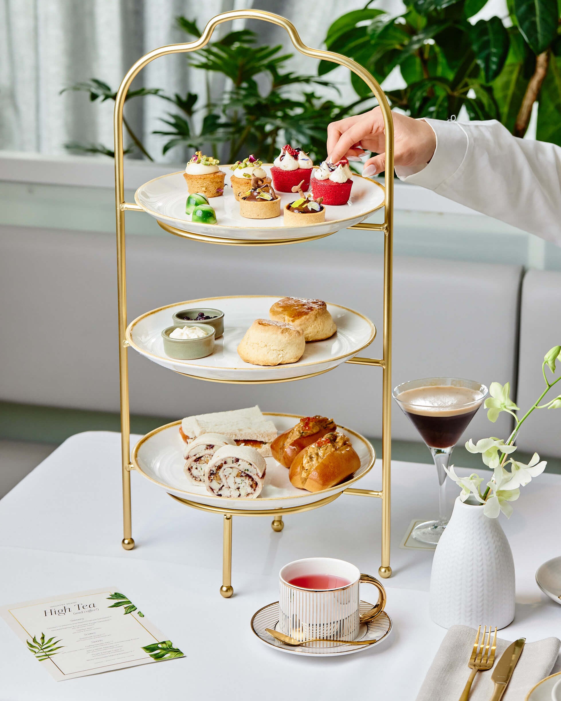 Person Selecting A Dessert From A High Tea Assortment