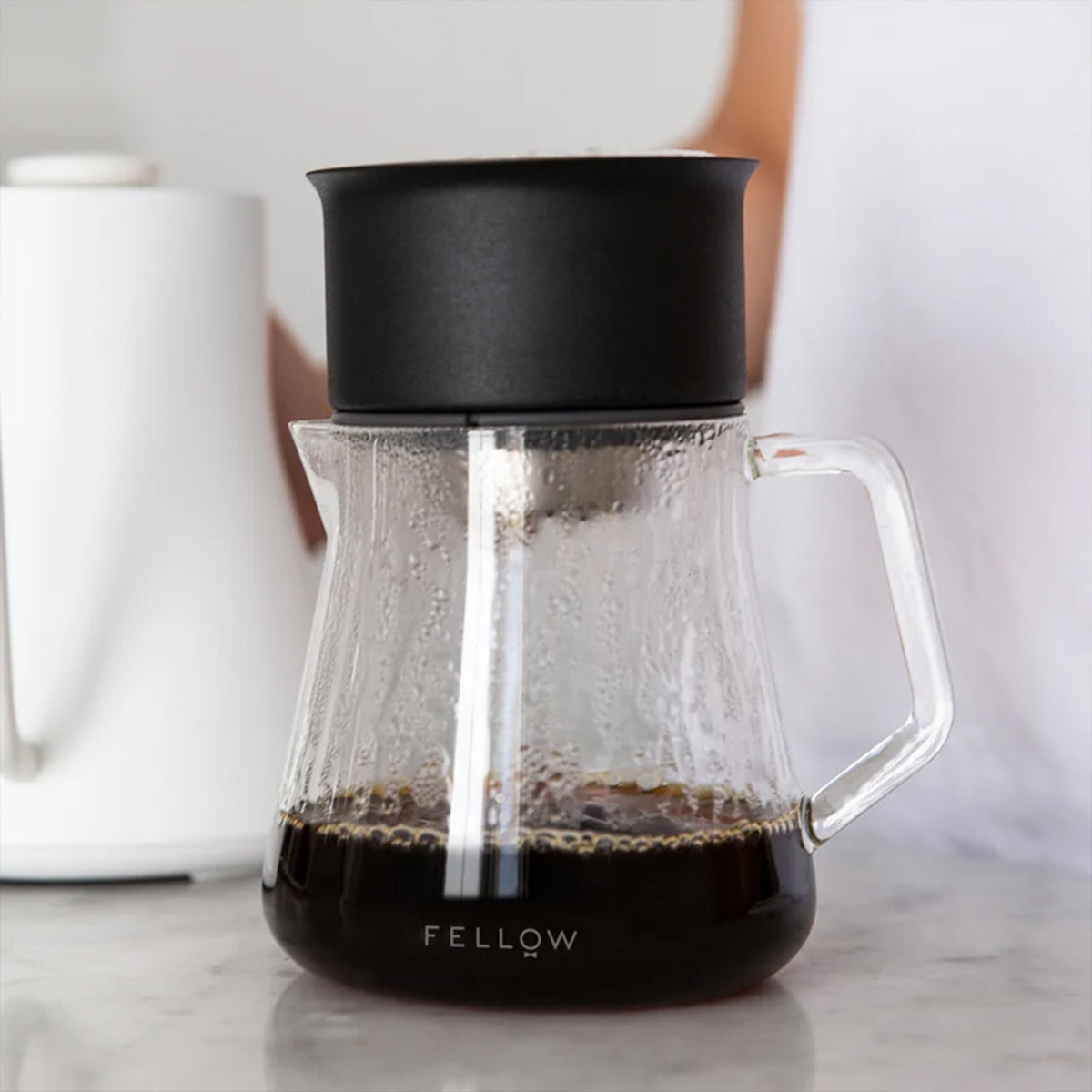 Fellow Mighty Small Glass Carafe with a black pour-over dripper on top, brewing coffee