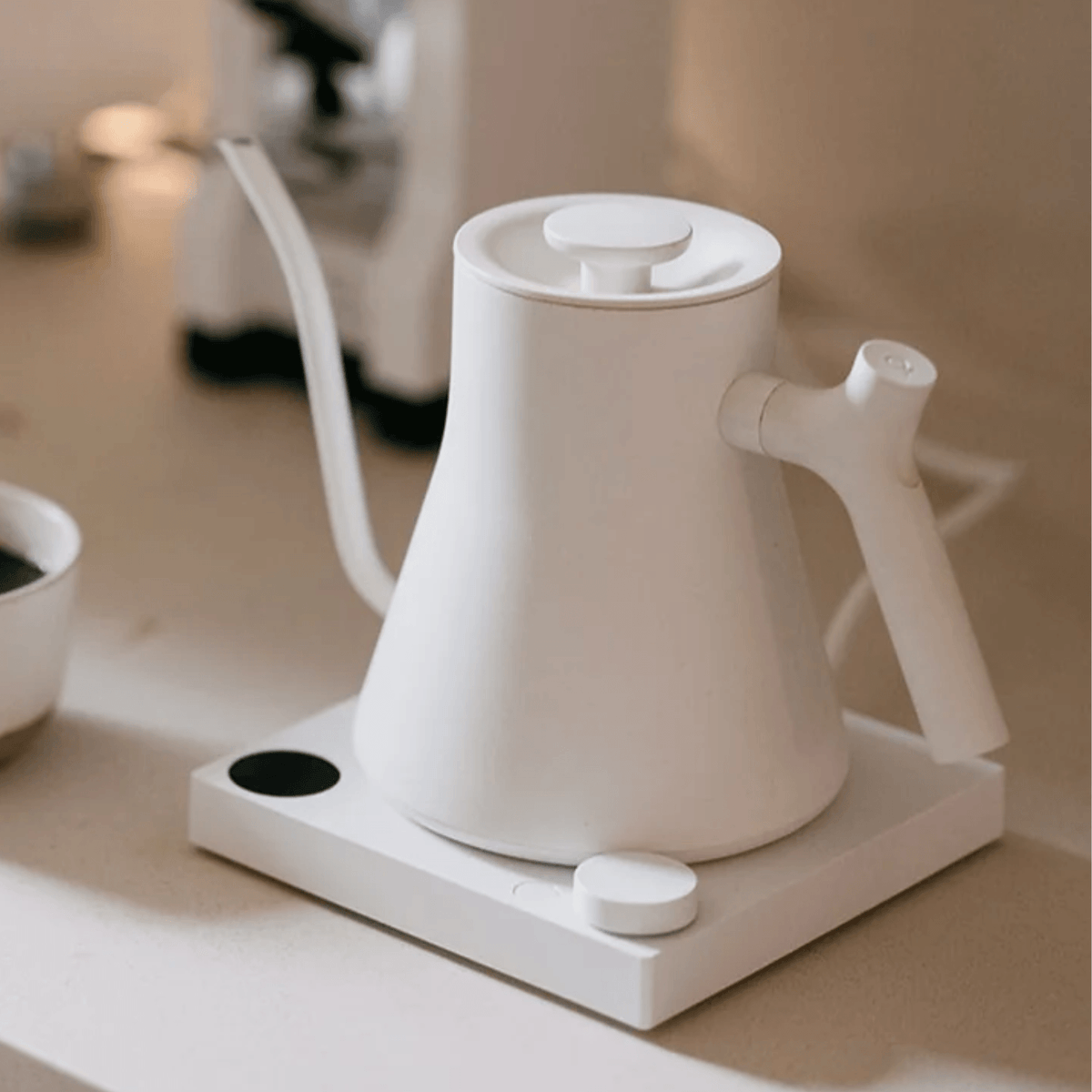 Matte White Fellow Stagg EKG Pro Electric Kettle on white bench