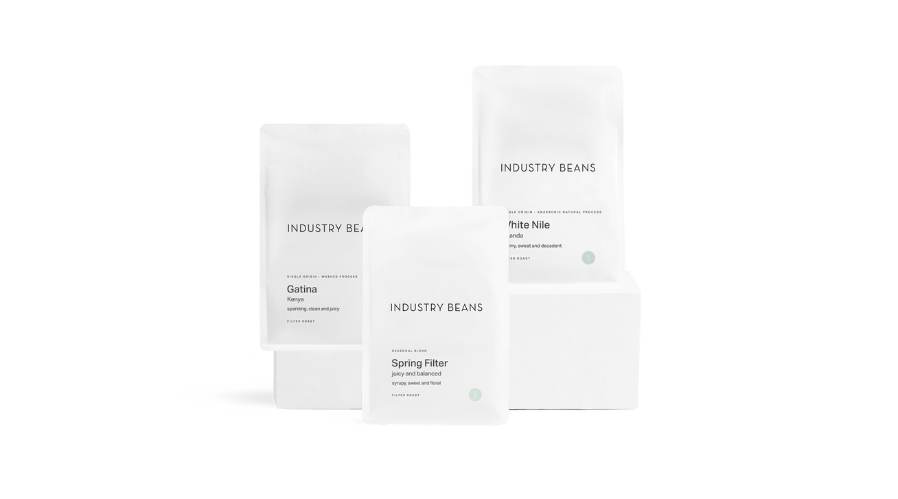 Set of coffee bags with 'Industry Beans' branding on a black background