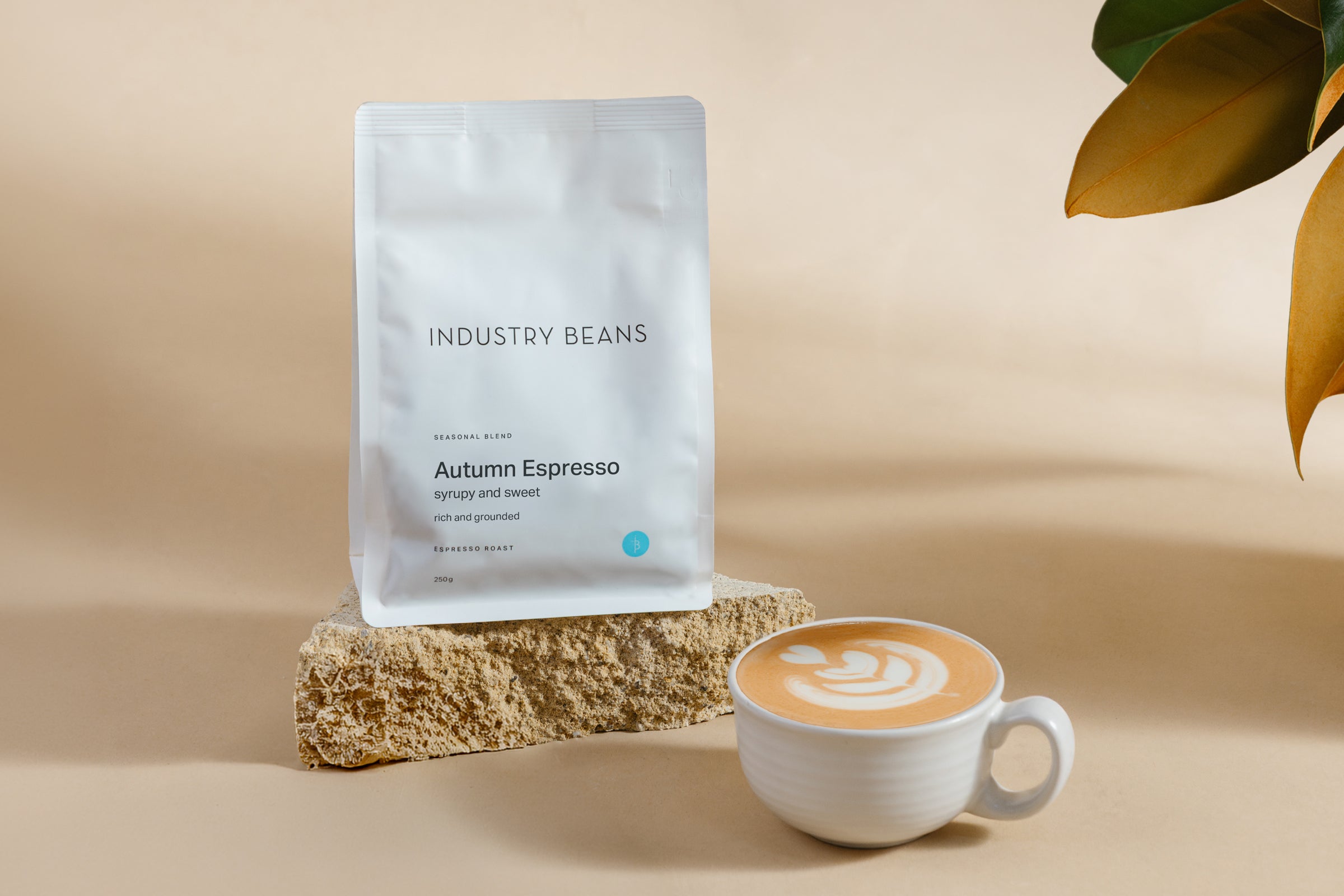 Industry Beans Autumn Espresso Coffee Beans Bag with ceramic mug of coffee with latte art