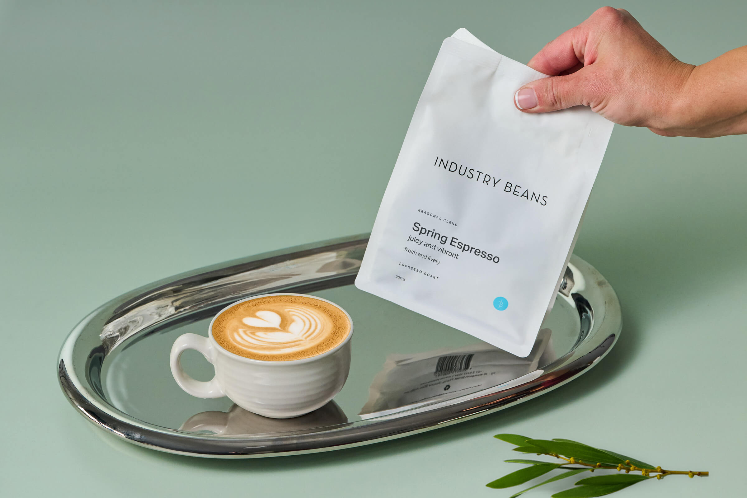Bag of Industry Beans Spring Espresso with a flat white mug on a silver tray