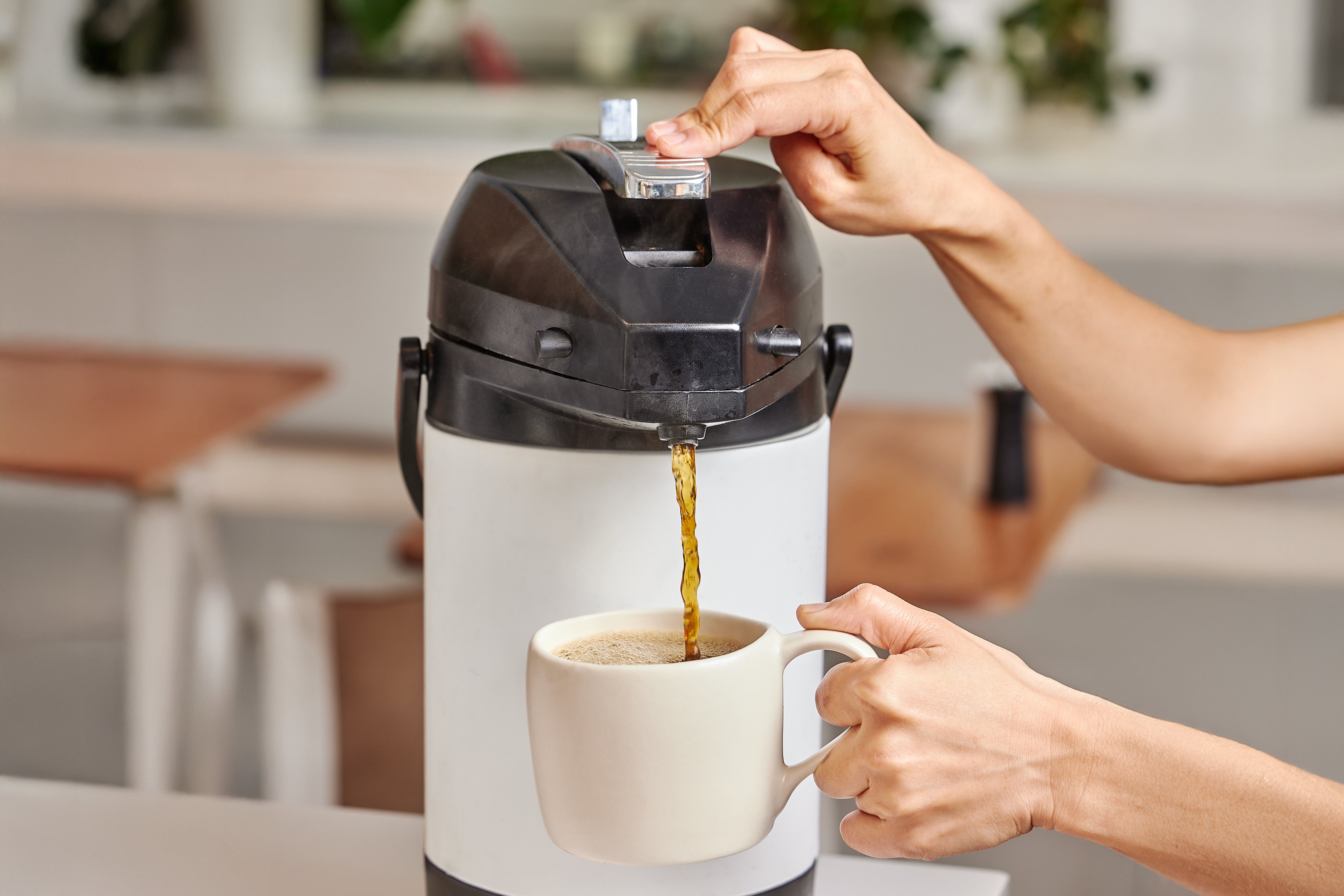 Filter coffee pouring from a jug into a mug
