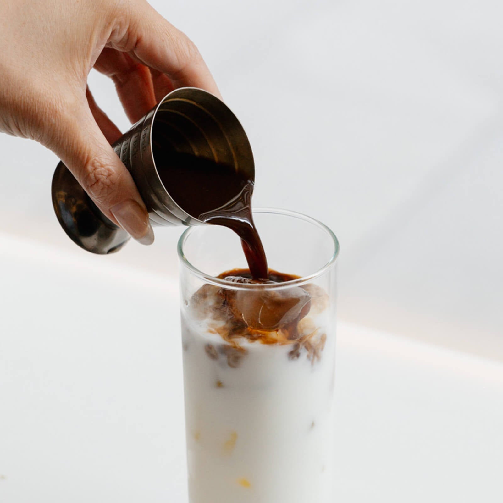 Shot of Cold Brew Coffee poured into milk and ice