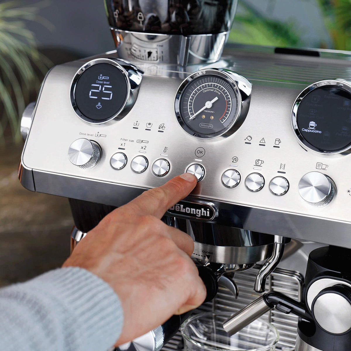 Espresso machine with digital display and control buttons, hand adjusting a knob.