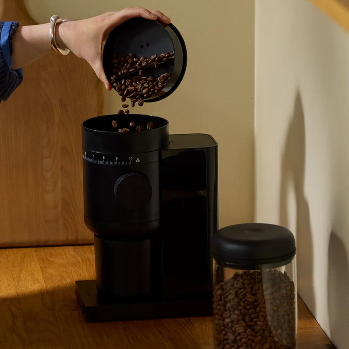 Coffee beans being poured into the Fellow Opus 2 Grinder